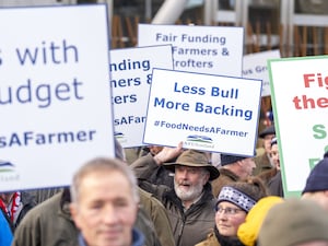 Farmers holding up placards at a rally