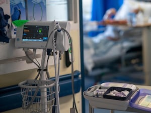 Hospital equipment and a blurred patient in a bed