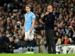 Manchester City substitute Kevin De Bruyne alongside manager Pep Guardiola on the touchline at a game at the Etihad Stadium