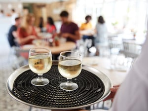 Tray with drinks carried by waiter at a restaurant, close up