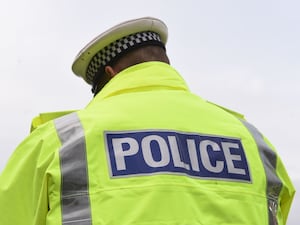 A police officer pictured from behind wearing a hi-vis jacket