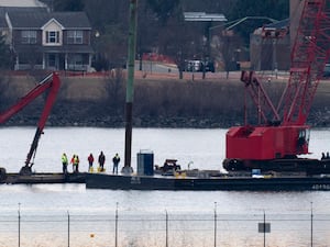 Rescue and salvage crews with cranes work near the wreckage