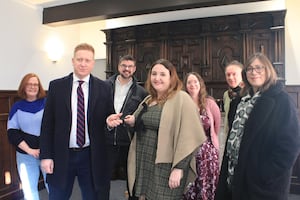 Lichfield District Council Leader Doug Pullen presents the key to The Schoolmaster’s House to Katie Gomez of Lichfield Discovered while fellow Lichfield Discovered volunteers (from left) Morwenna Rae, John Tanner, Teresa Gilmore, John Gallagher and Jacky Billingsley look on.