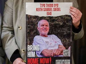 Tal Wax poses in Madrid with a poster showing her uncle Keith Siegel, an Israeli-American hostage held in Gaza since the October 7 attacks by Hamas