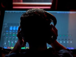 Man wearing headphones in front of a screen