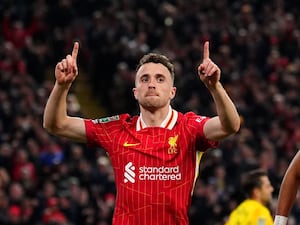 Liverpool forward Diogo Jota points both index fingers to the sky in celebration