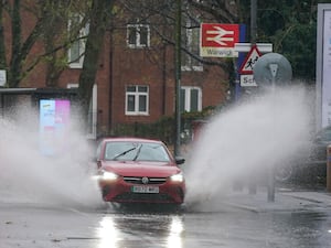 A vehicle is driven through floodwater after heavy rain in Warwick