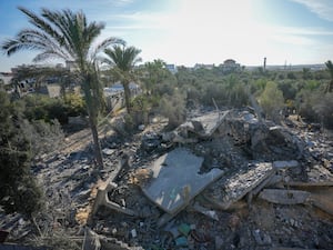 Palestinians look at home destroyed by an Israeli strike late Saturday in Deir al-Balah