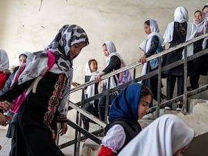 Girls walking down a slight of stairs as they attend school on the first day of the new school year, in Kabul, Afghanistan, on March 25, 2023