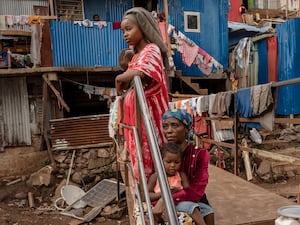 Women stand amid the destroyed buildings on the island of Mayotte