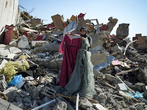 Nour Abu Al Zamar salvage items from under the rubble of her destroyed family home, in Rafah, southern Gaza