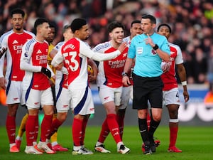 Referee Michael Oliver was confronted by Arsenal's players after his decision to send off Myles Lewis-Skelly, right, at Molineux