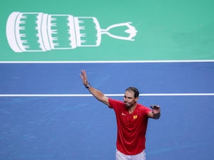 Rafael Nadal holds his hands up to salute the crowd