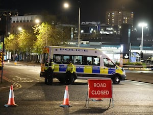 Police officers and vehicle beside a road closure sign