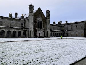 Staff member at the University of Galway clearing snow from pathways