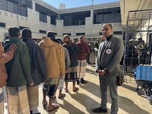 Captives released by the Houthis stand in a queue