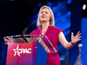 Liz Truss gestures with her arms as she makes a speech