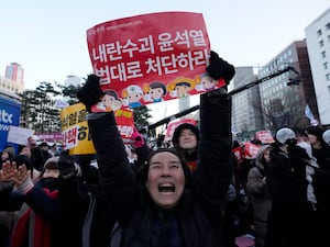 Participants celebrate after hearing the news that South Korea’s parliament voted to impeach President Yoon Suk Yeol