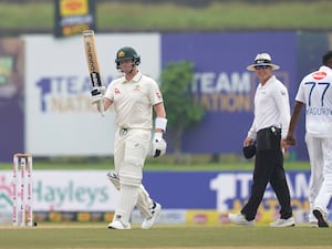 Steve Smith lifts his bat after reaching 10,000 career Test runs