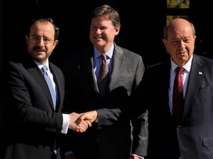 United Nations Chief of Mission in Cyprus Colin Stewart stands between Cypriot President Nikos Christodoulides