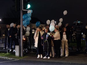 People with balloons attending a nighttime vigil