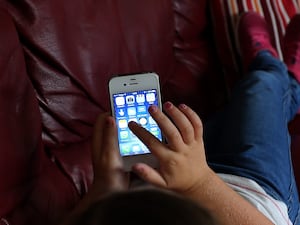 Aerial view of a child accessing social media apps on a smartphone