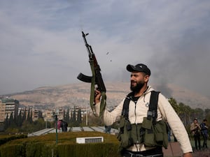 Opposition fighter with gun raised