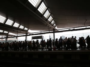 A crowd of people wait on a platform at Blackfriars station, London