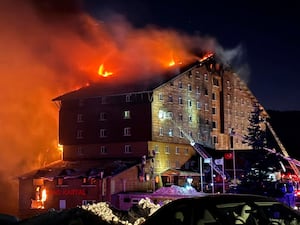 Firefighters work to extinguish a fire in a hotel at a ski resort of Kartalkaya in Bolu