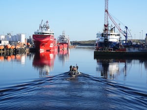 Police boat in harbour water, with ships in the background