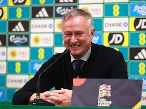 Michael O'Neill laughs as he talks to the media