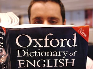 A man reading a copy of the Oxford Dictionary of English