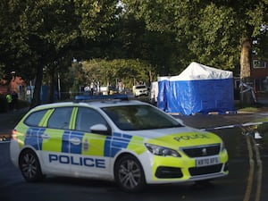 A police car and incident tent at the scene of the shooting