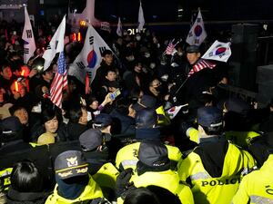 Police officers stand guard as supporters of impeached South Korean President Yoon Suk Yeol try to enter the Seoul Western District Cour