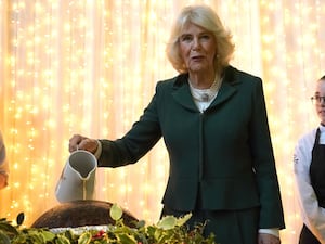 Camilla pours brandy over a Christmas pudding