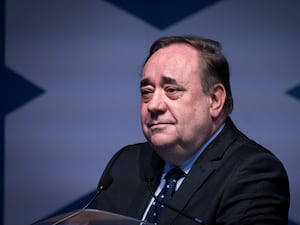 Head and shoulders photo of Alex Salmond in front of a Saltire flag