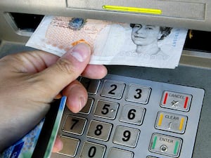 A banknote being withdrawn from an ATM