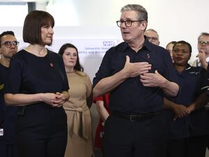 Chancellor Rachel Reeves and Prime Minister Sir Keir Starmer standing in front of NHS staff as Sir Keir gestures and speaks