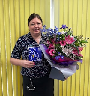 Joanne Jones, pictured with her IRIS Award and bouquet of flowers.