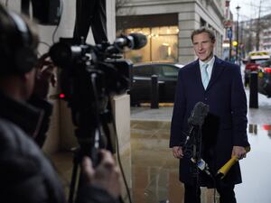 Chris Philp speaking into a microphone in front of a TV camera