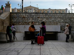 Commuters stand outside the closed main metro Syntagma station