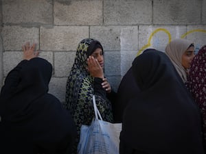 A Palestinian woman waits in line for food at a distribution centre in Deir al-Balah, Gaza Strip