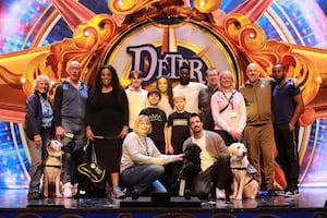 A selection of cast members from Peter Pan with Puppy Raisers and puppies from Guide Dogs.