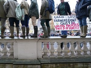 Protesting farmers standing on a wall in central London