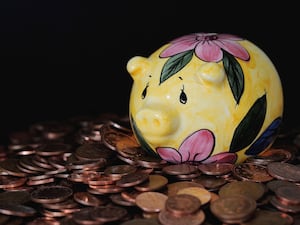 A piggy bank on top of a pile of coins