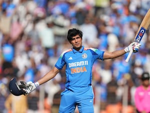 Shubman Gill celebrates his century by raising his bat