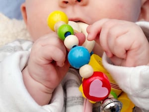 A baby's hands playing with a toy