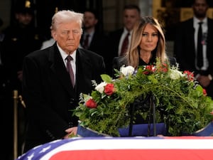 President-elect Donald Trump and Melania Trump pause at the flag-draped casket of former President Jimmy Carter