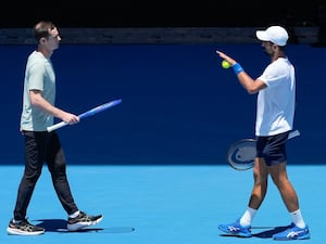 Novak Djokovic talks with his coach Andy Murray, left, during a practice session