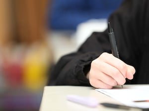 A close -up of a boy's hand writing on a piece of paper